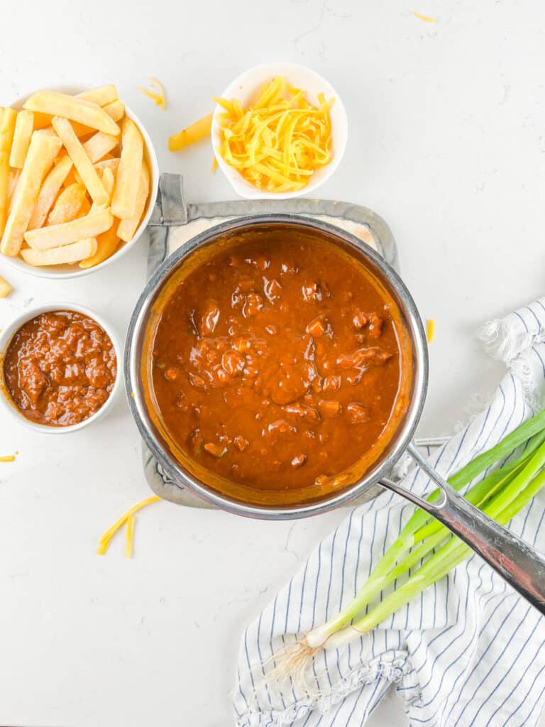 process shot of chili cheese fries being made.