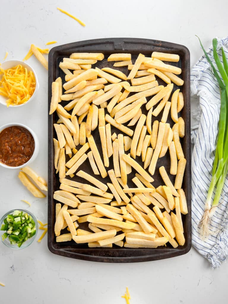 process shot of chili cheese fries being made.