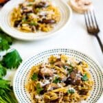 orzo laid out on a spotted white plate with mushrooms.