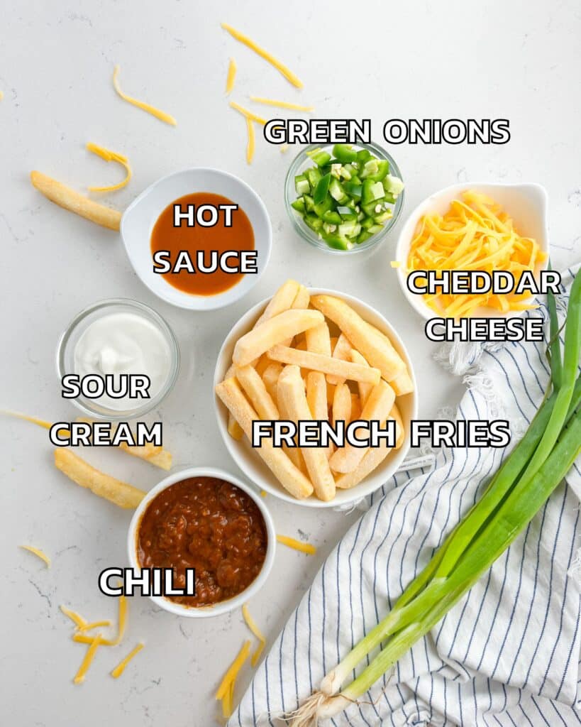 ingredients in chili cheese fries on a white marble counter.