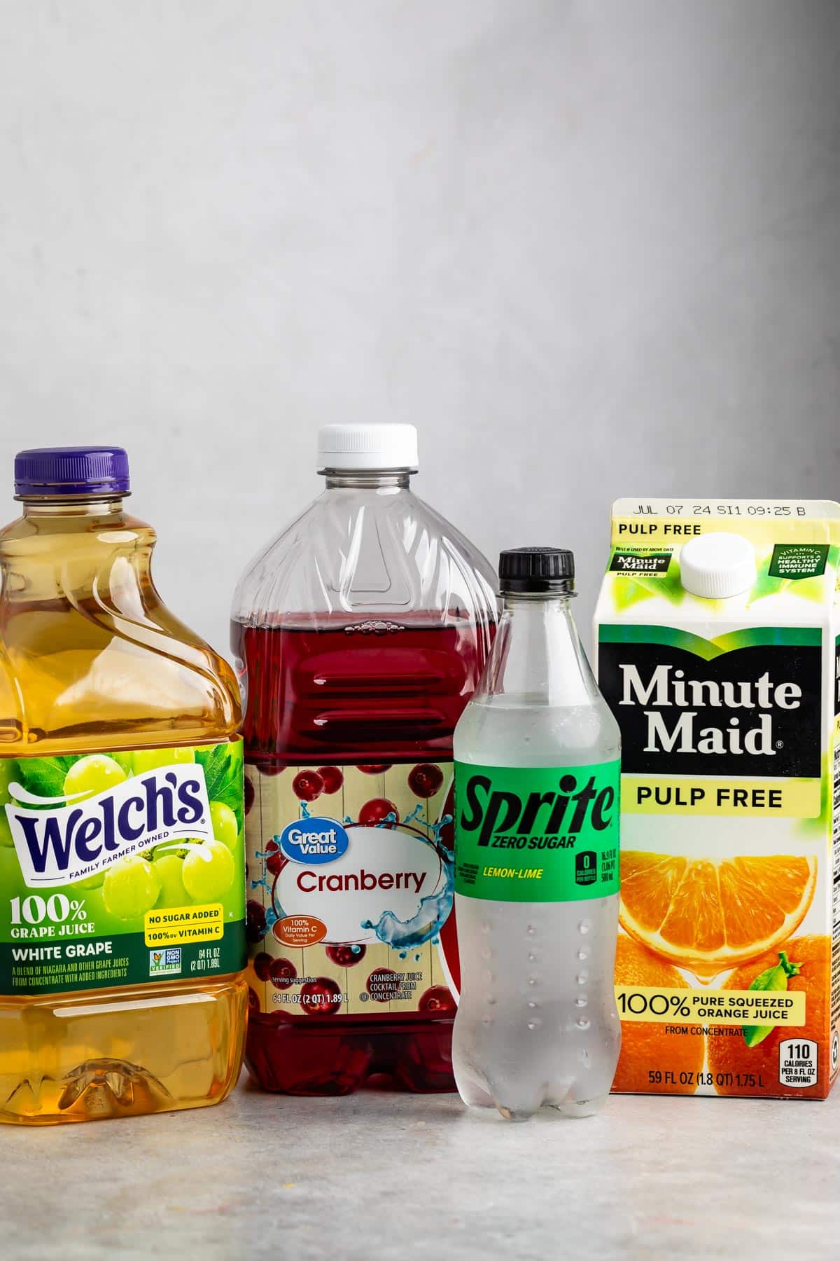 ingredients in non alcoholic sangria laid out on a grey counter.