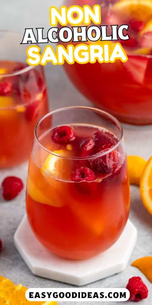 red drink in a clear glass with lemon and raspberries inside and with words the image.