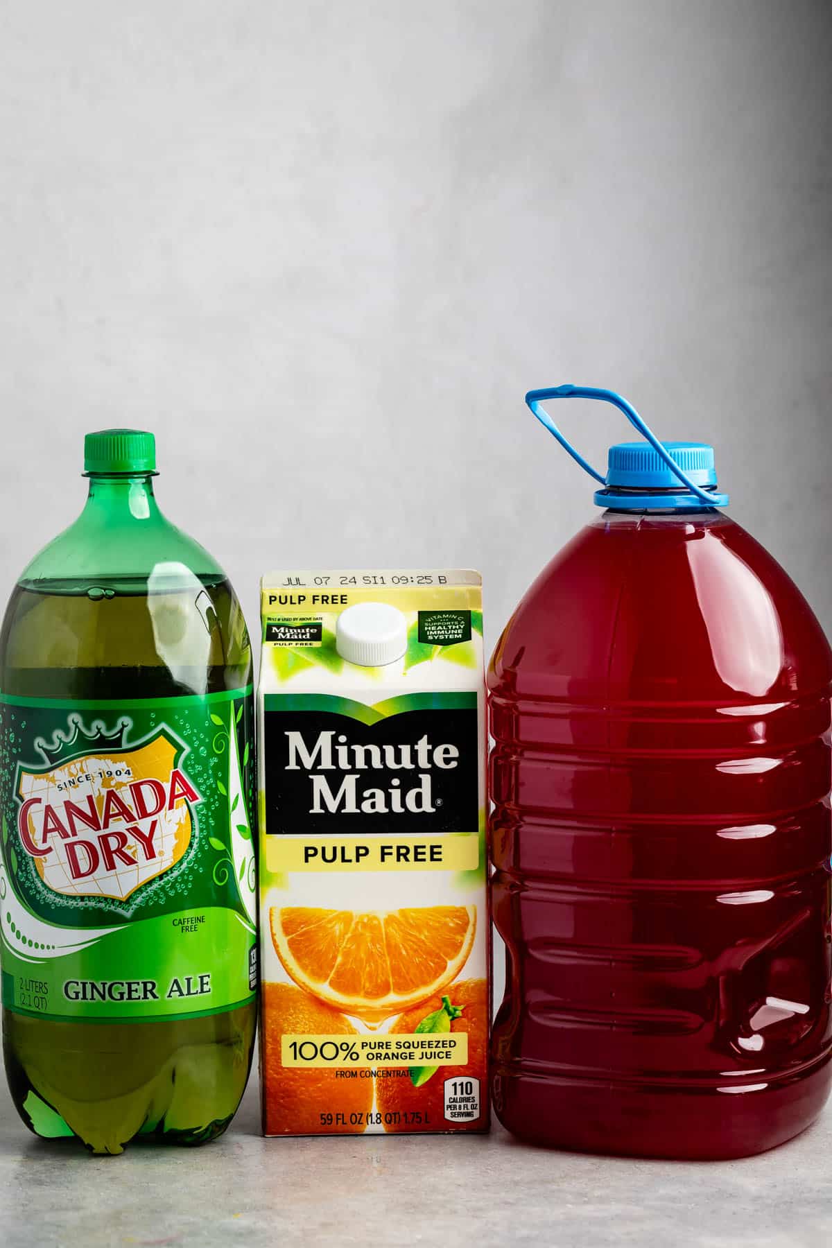 ingredients in party punch laid out on a grey counter.