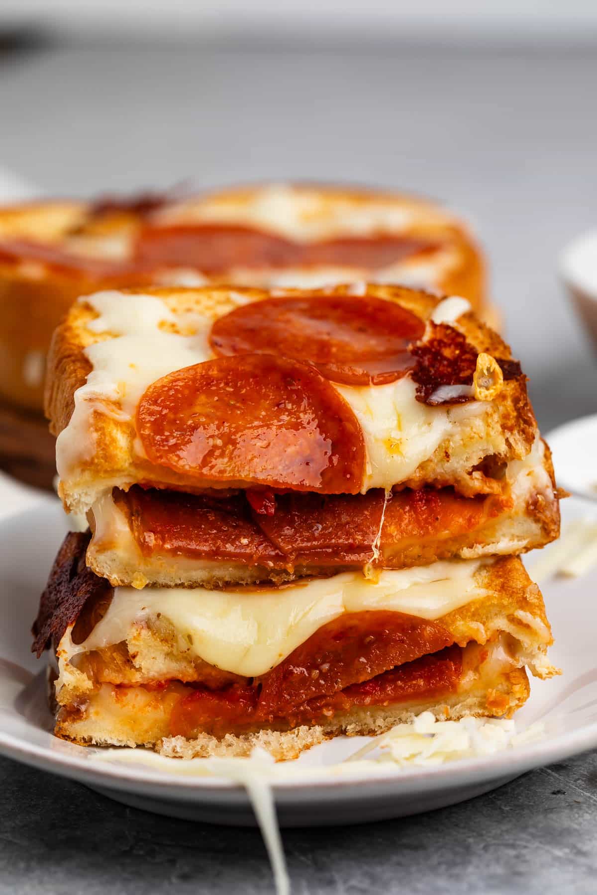 stacked grilled cheese with pepperoni baked on top and inside the sandwich.