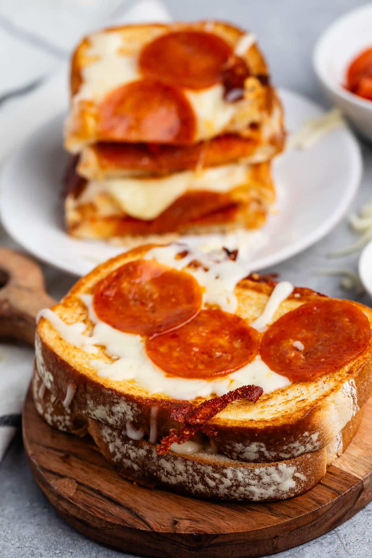 stacked grilled cheese with pepperoni baked on top and inside the sandwich.