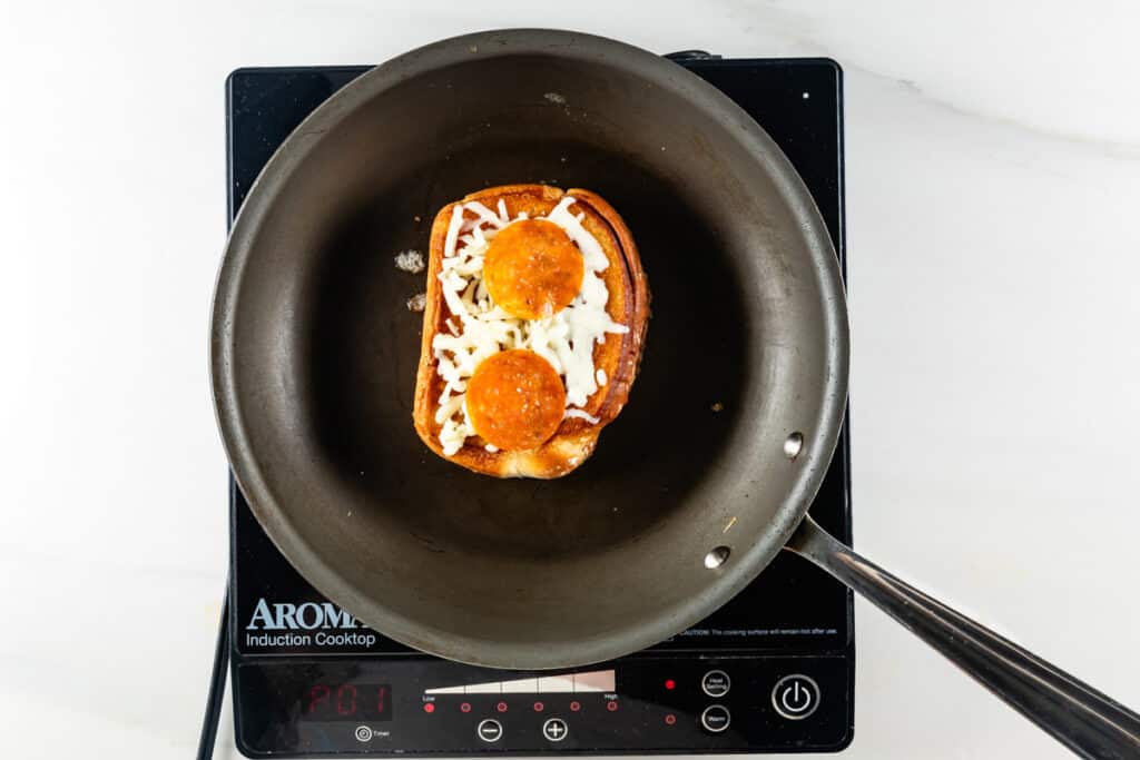 process shot of pizza grilled cheese being made.