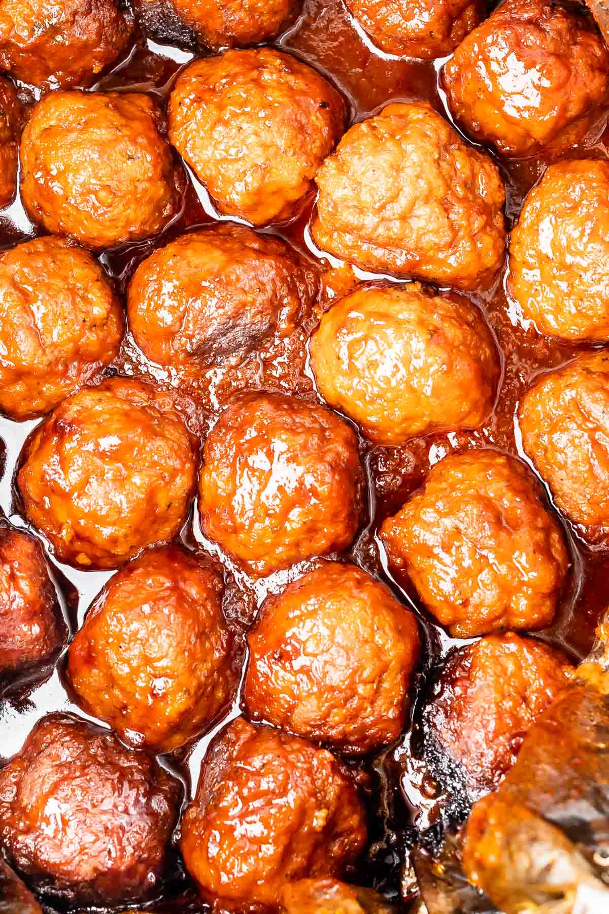 meatballs on a white plate covered in sauce.