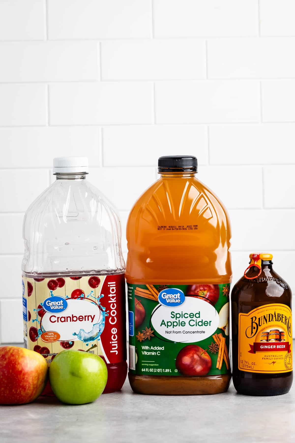 ingredients in apple punch laid out on a grey counter.