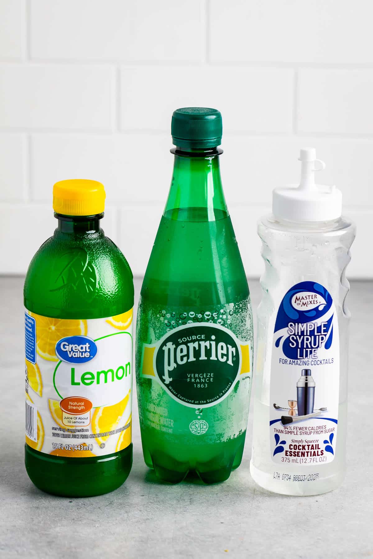 ingredients in tom collins laid out on a grey counter.