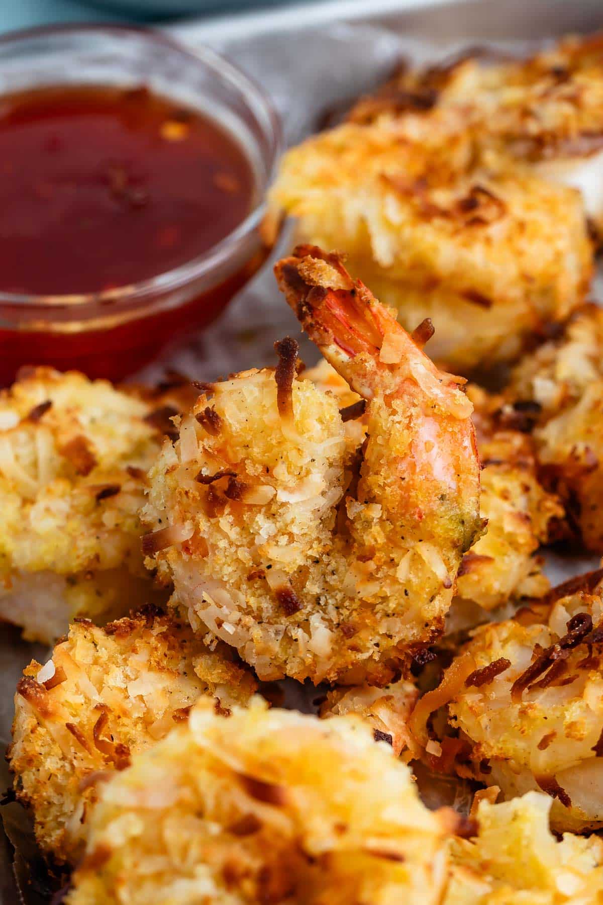 stacked shrimp on a pan next to a sauce.