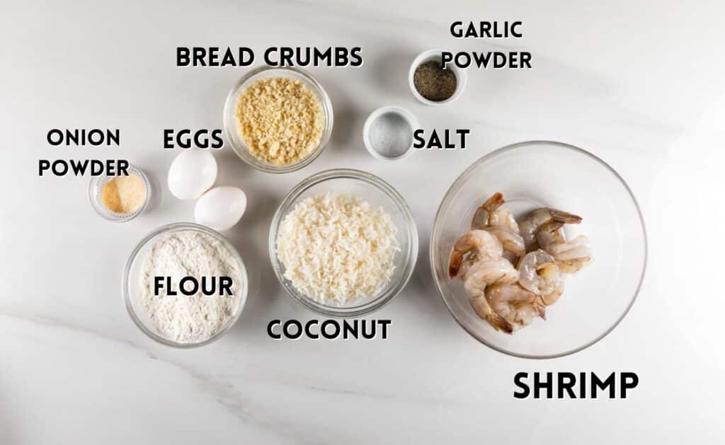 ingredients in coconut shrimp laid out on a white counter.