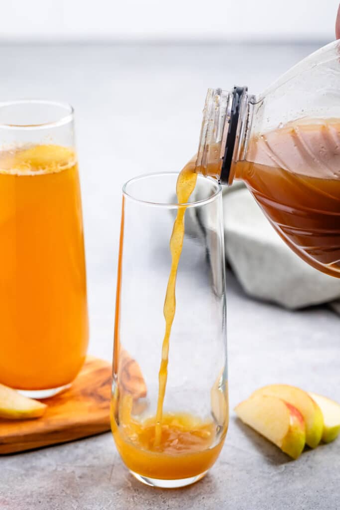 process shot of apple cider mocktail mimosa being made.