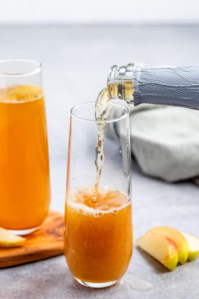 process shot of apple cider mocktail mimosa being made.