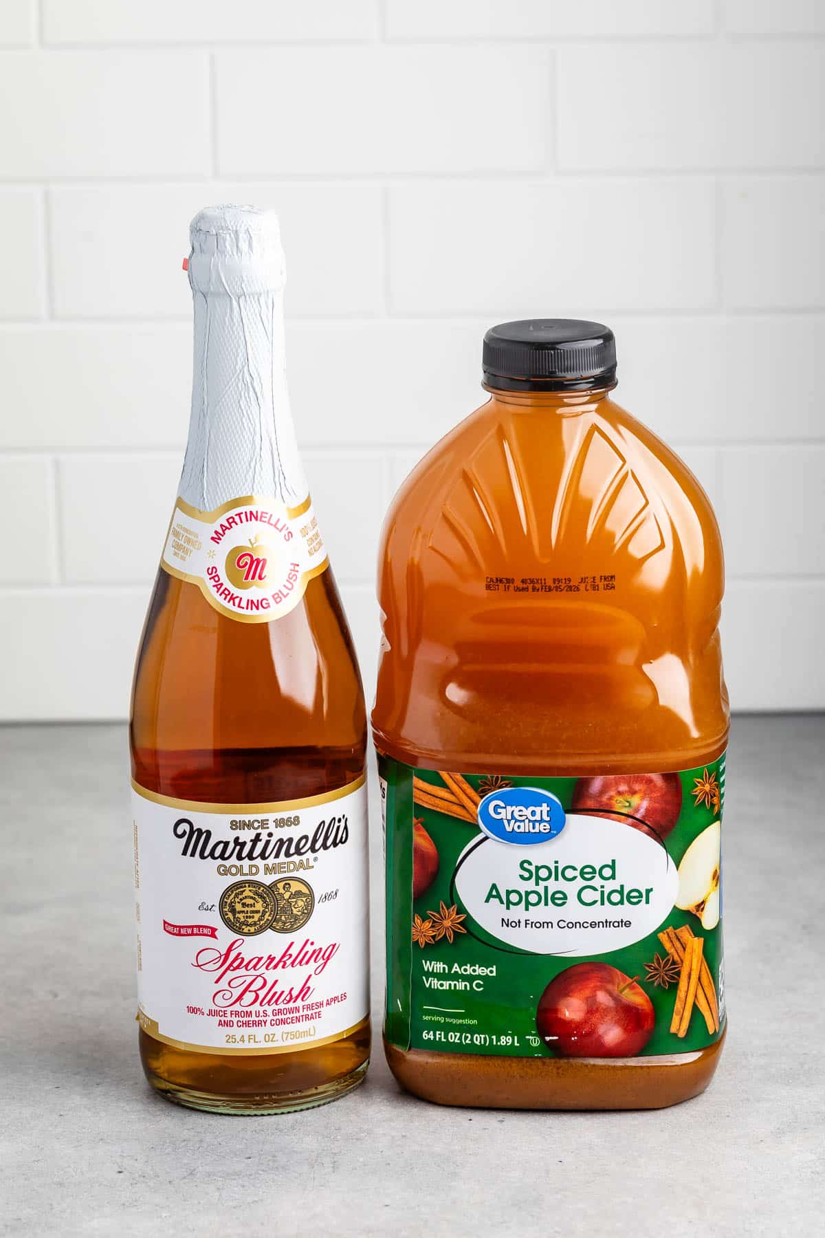 ingredients in apple cider mocktail mimosa laid out on a grey counter.