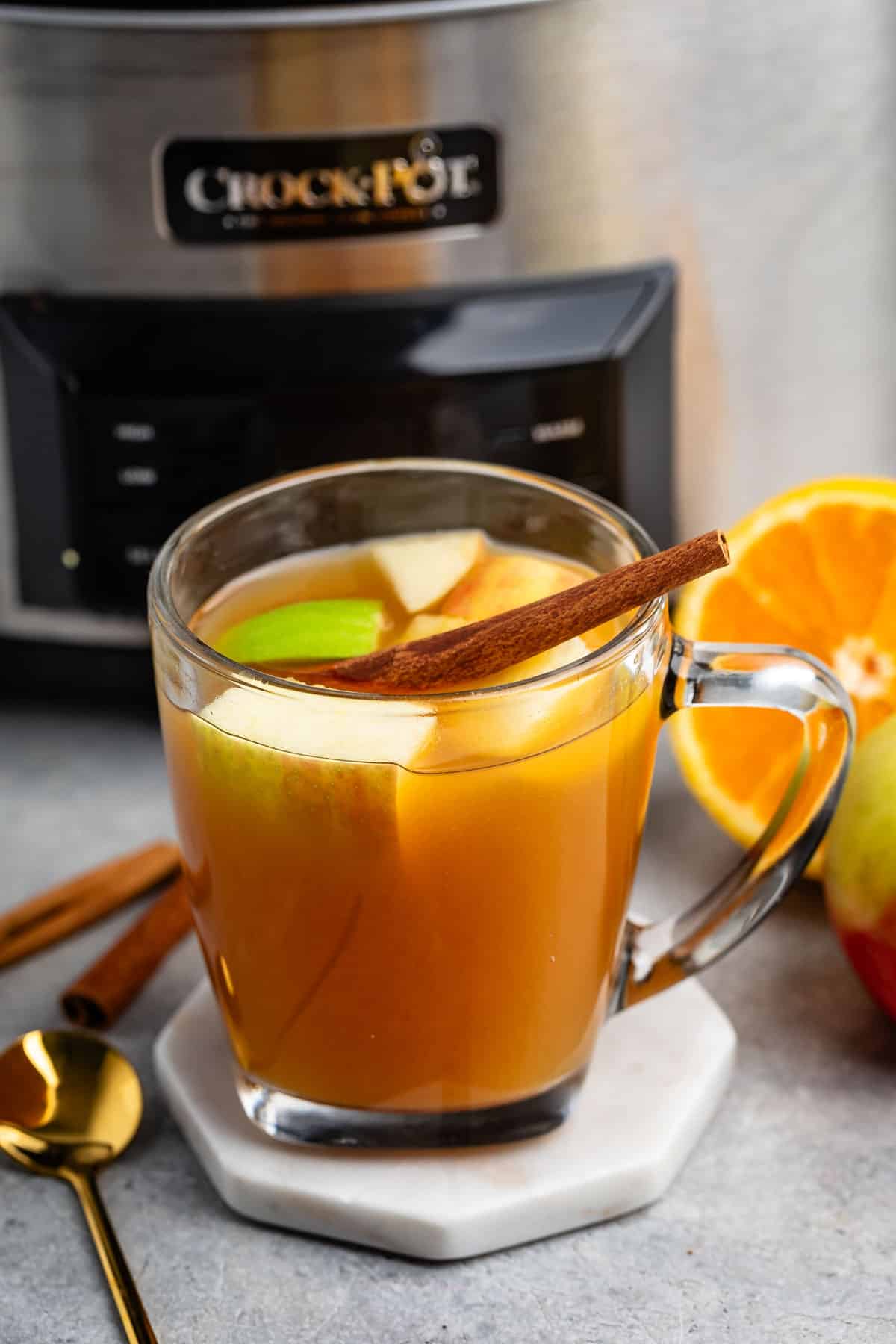 apple cider mixed with apples and cinnamon sticks and orange slices.