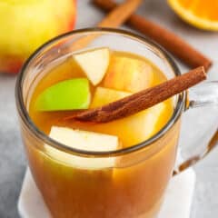 apple cider mixed with apples and cinnamon sticks and orange slices.