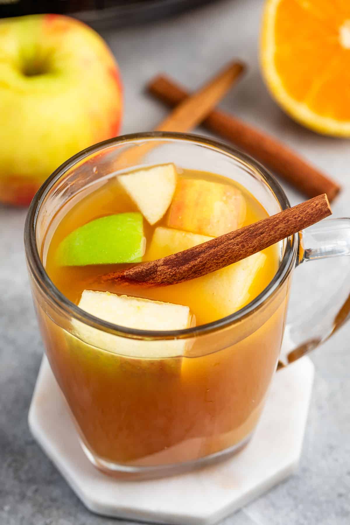 apple cider mixed with apples and cinnamon sticks and orange slices.