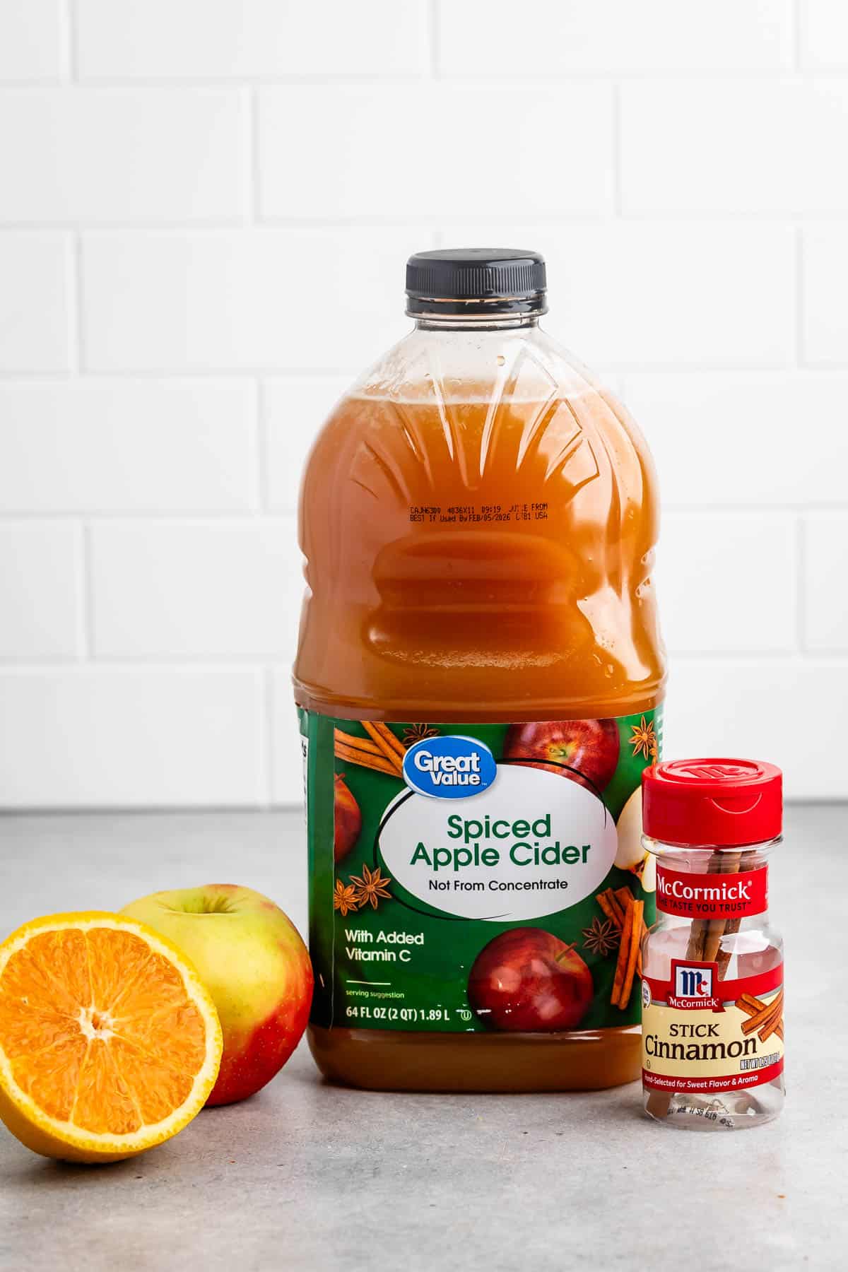 ingredients in crockpot apple cider laid out on a grey counter.