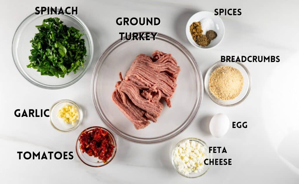 ingredients in greek turkey burgers laid out on a white counter.