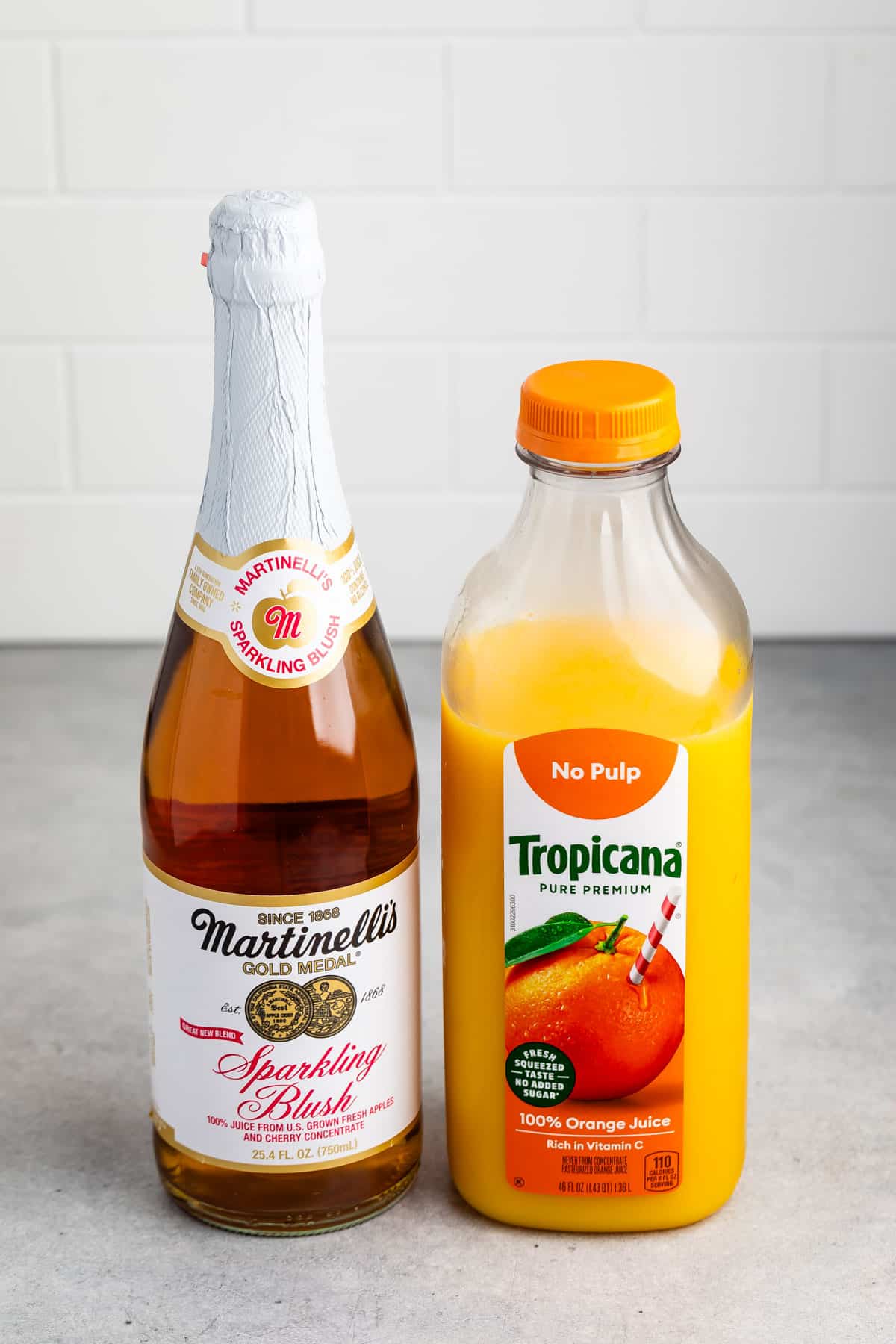 ingredients in virgin mimosa laid out on a grey counter.