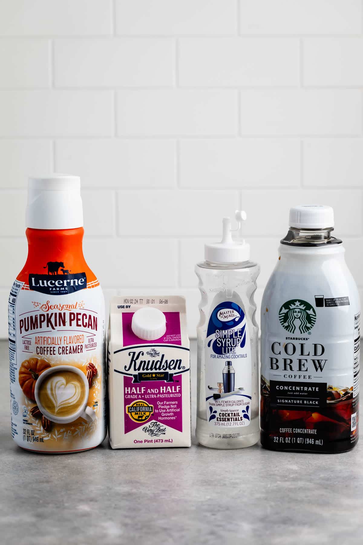 ingredients in pumpkin spice White Russian laid out on a grey counter.