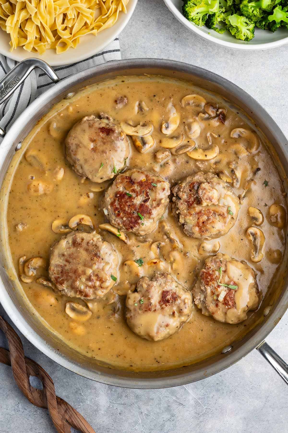 steak in a silver pan with gravy pored over top.