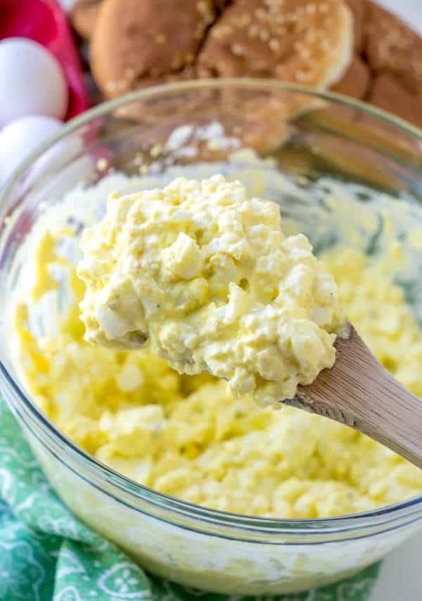 egg salad scooped onto a wooden spoon.