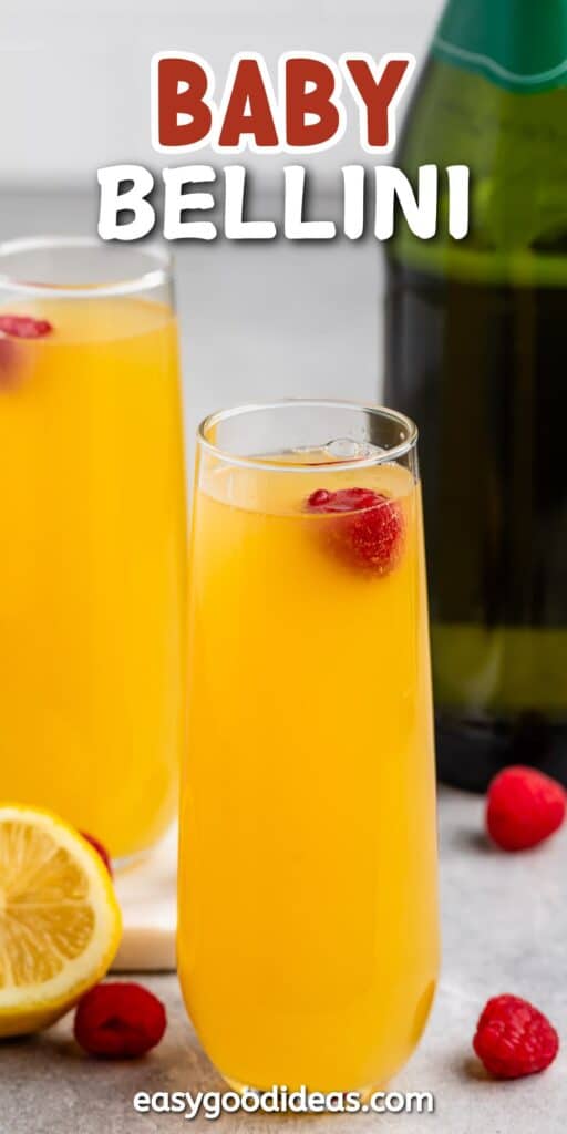 Two tall glasses filled with orange Bellini cocktails, garnished with fresh raspberries. A lemon slice is visible nearby. A bottle is in the background. The text Baby Bellini is displayed at the top, with a website link at the bottom.