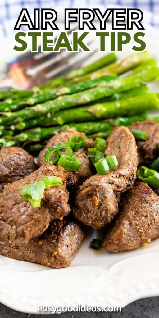 A plate of air fryer steak tips garnished with chopped green onions, accompanied by roasted asparagus. The text AIR FRYER STEAK TIPS is at the top, and easygoodideas.com is at the bottom.