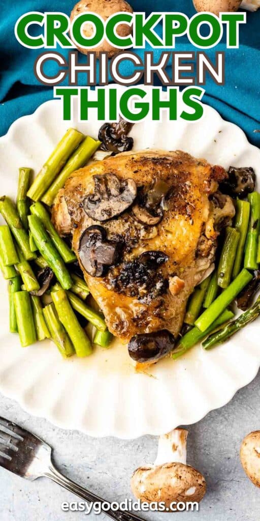 A plate of crockpot chicken thighs with mushrooms and green beans, served on a white dish. A fork and a whole mushroom are placed nearby on a textured surface. The text Crockpot Chicken Thighs appears at the top.