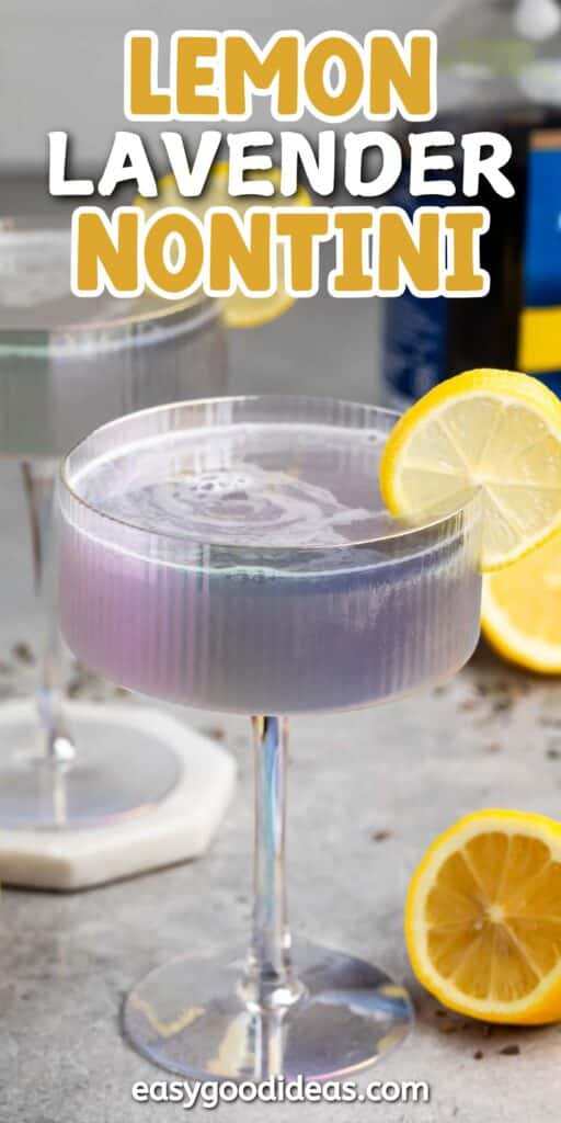 A cocktail glass filled with a purple lemon lavender nontini, garnished with a lemon slice. Another similar drink is in the background. Lemons are scattered on the table, and text at the top reads Lemon Lavender Nontini.