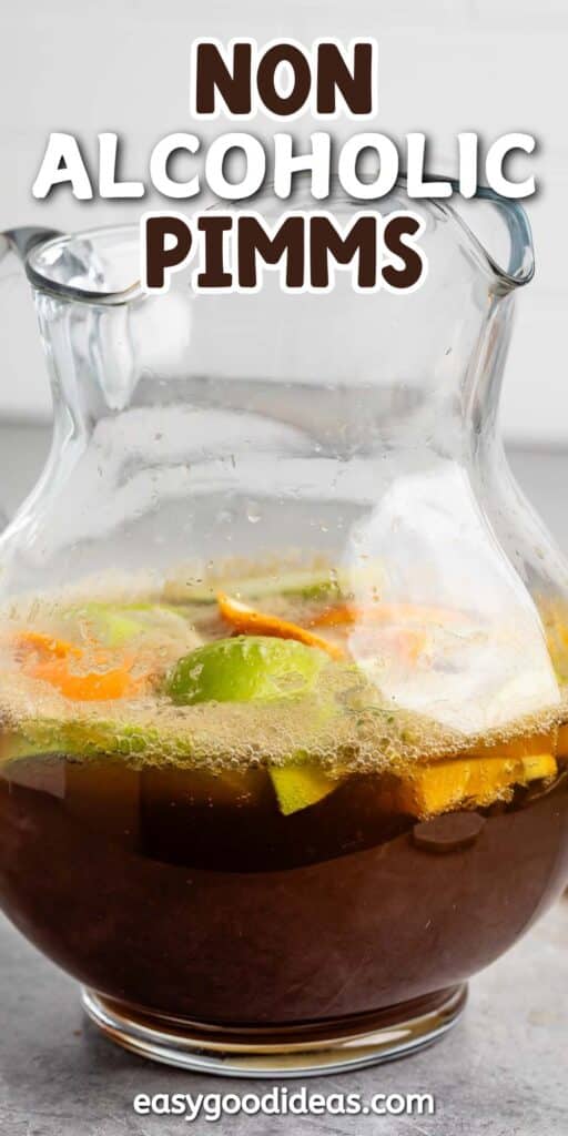 A glass pitcher filled with a non-alcoholic Pimms beverage, containing visible slices of orange, lemon, and lime. Bubbles are visible on the surface. The background is a neutral color, and text at the top reads Non Alcoholic Pimms.