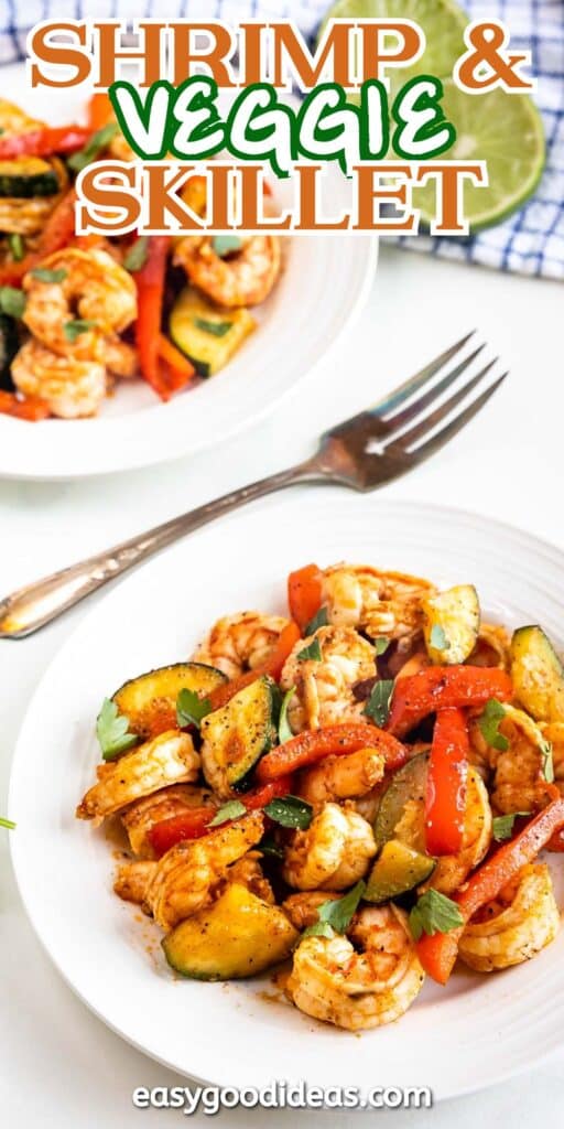 A white plate filled with shrimp, red bell peppers, zucchini, and herbs. Another plate with the same dish is blurred in the background. A fork rests beside the front plate. The text Shrimp & Veggie Skillet is visible at the top.