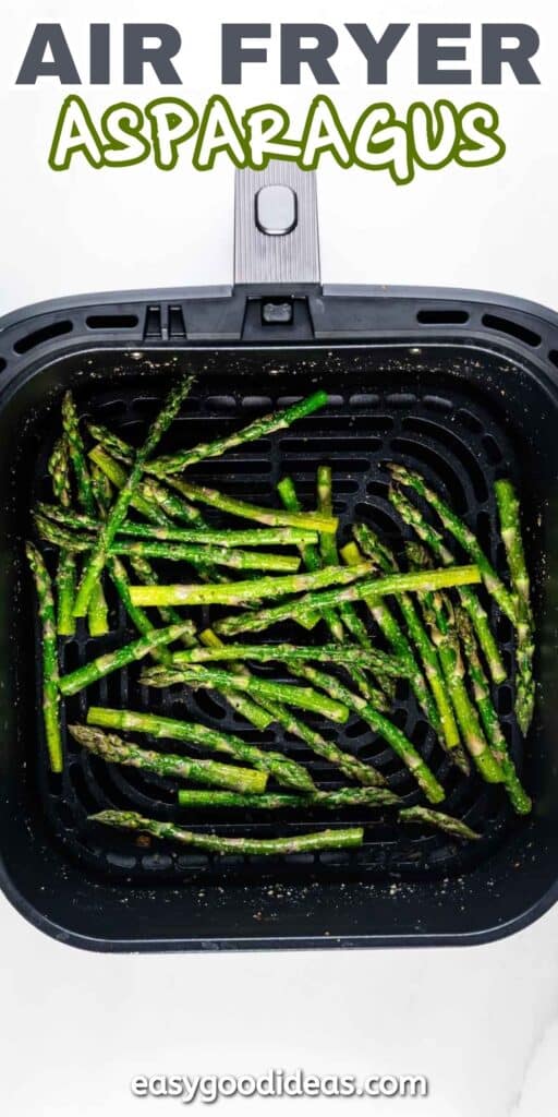 A black air fryer basket filled with cooked asparagus spears. The asparagus is seasoned and slightly browned. The top text reads AIR FRYER ASPARAGUS, and the bottom text says easygoodideas.com.