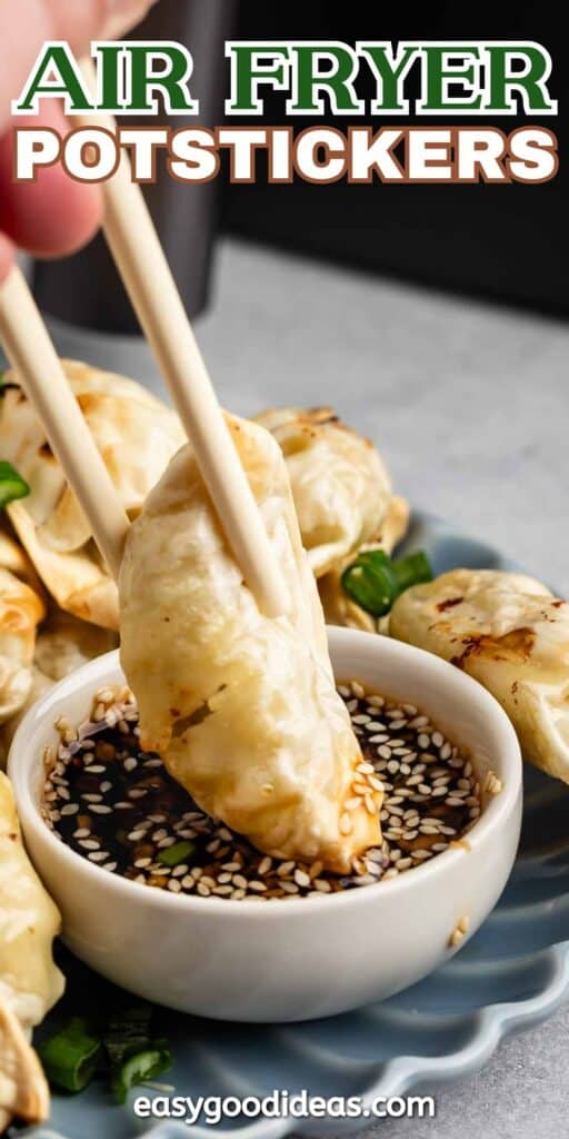 A close-up of chopsticks holding a potsticker above a bowl of soy sauce with sesame seeds. Other potstickers are on a plate in the background. Text at the top reads Air Fryer Potstickers and at the bottom easygoodideas.com.