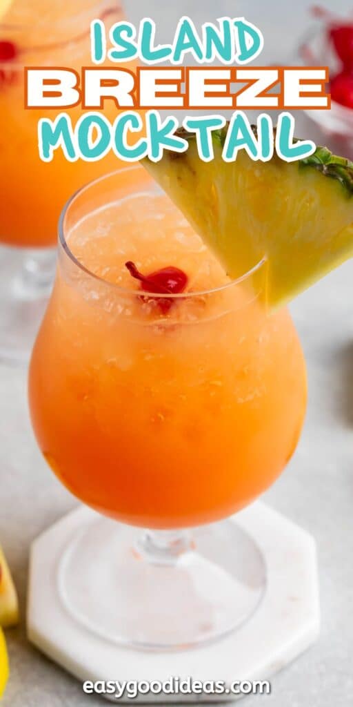 A tropical mocktail in a glass garnished with a pineapple slice and a cherry. The beverage is a vibrant orange color, sitting on a white coaster. Text at the top reads Island Breeze Mocktail.