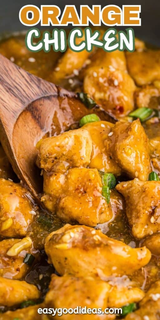 Close-up of a wooden spoon stirring chunks of orange chicken with a glossy sauce, garnished with sliced green onions. The text Orange Chicken is at the top with easygoodideas.com at the bottom.
