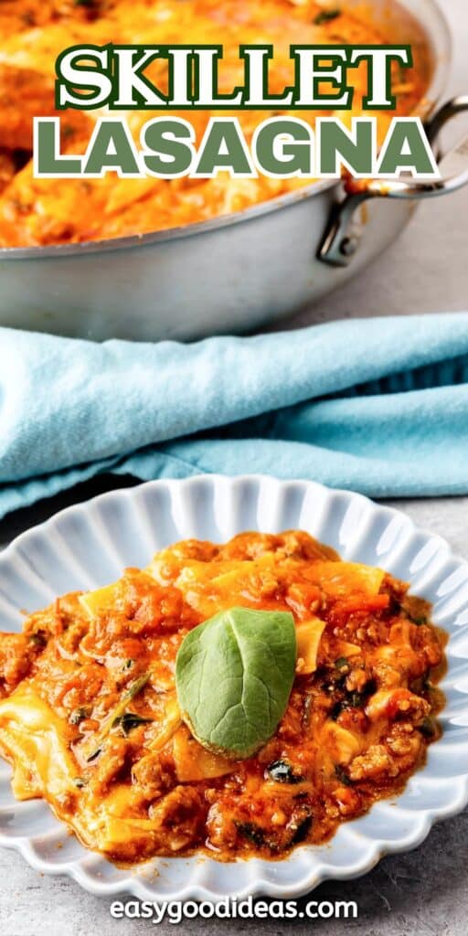 skillet lasagna on a grey plate with some green garnish on top and with more lasagna in the background and with words on the image reading the name of the recipe.