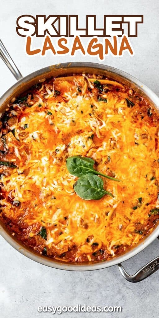 skillet lasagna in a silver skillet pan with some green garnish on top and with words on the image reading the name of the recipe.