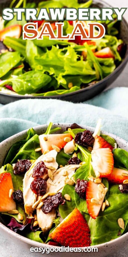 A bowl of salad featuring fresh spinach, sliced strawberries, grilled chicken pieces, dried cranberries, and sunflower seeds. Another similar salad is visible in the background. Text at the top reads STRAWBERRY SALAD, and at the bottom easygoodideas.com.