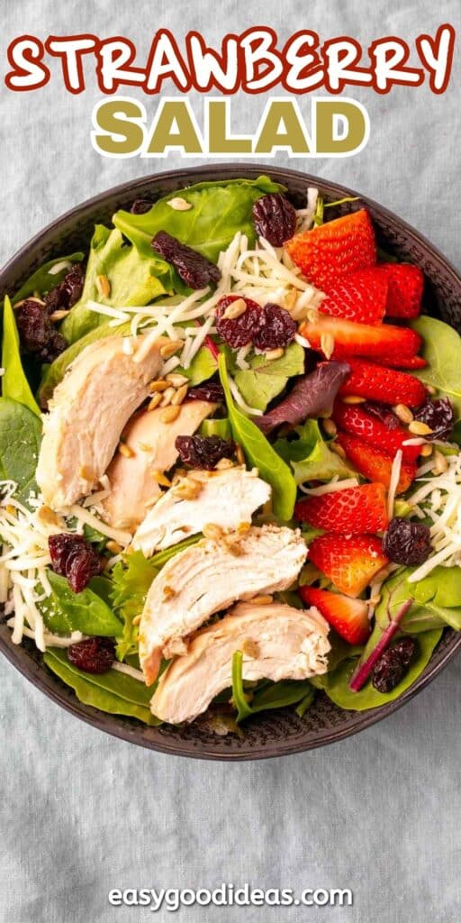 A bowl of strawberry salad with sliced chicken, fresh strawberries, dried cranberries, shredded cheese, spinach, and mixed greens. The text Strawberry Salad is at the top, and easygoodideas.com is at the bottom.