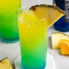 yellow and green drink with a pineapple slice on the rim.