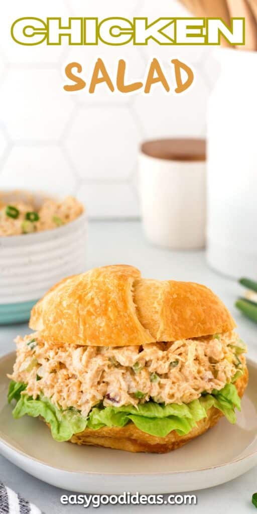 A croissant sandwich filled with chicken salad and lettuce sits on a plate. In the background, a bowl of chicken salad is visible. The text CHICKEN SALAD is at the top, and easygoodideas.com is at the bottom.