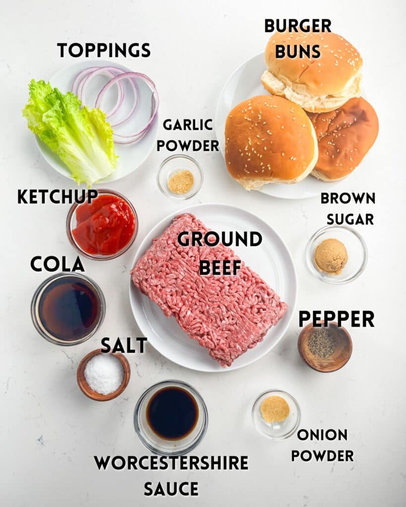 Ingredients for making burgers displayed on a white surface: ground beef, burger buns, lettuce, onion slices, ketchup, cola, Worcestershire sauce, garlic powder, salt, brown sugar, pepper, and onion powder.