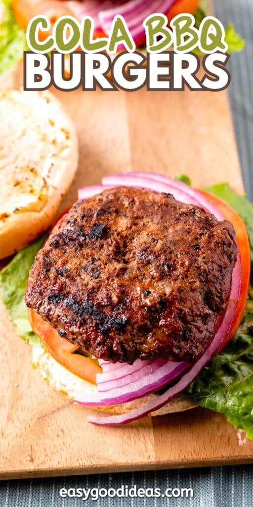 A close-up of a burger on a wooden board. The burger includes a grilled patty, lettuce, tomato slices, and red onion rings. The top bun is off to the side. Text at the top reads Cola BBQ Burgers, and the website easygoodideas.com is at the bottom.