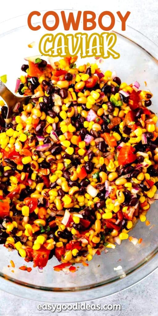 A bowl of colorful cowboy caviar salad with black beans, corn, chopped tomatoes, red onion, and green herbs. The text reads Cowboy Caviar and easygoodideas.com appears at the bottom.