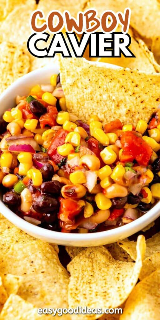 A white bowl filled with colorful cowboy caviar dip, featuring corn, black beans, tomatoes, onions, and peppers, surrounded by tortilla chips. Text above reads Cowboy Caviar, and easygoodideas.com is at the bottom.