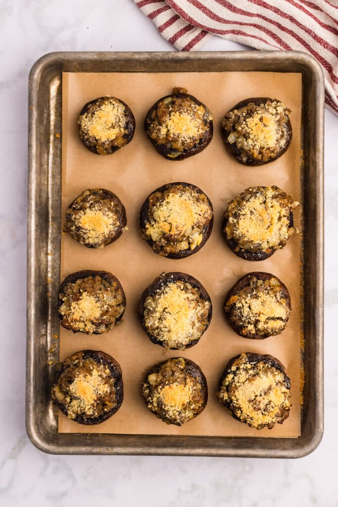 A plate of stuffed mushrooms topped with breadcrumbs and chopped herbs.