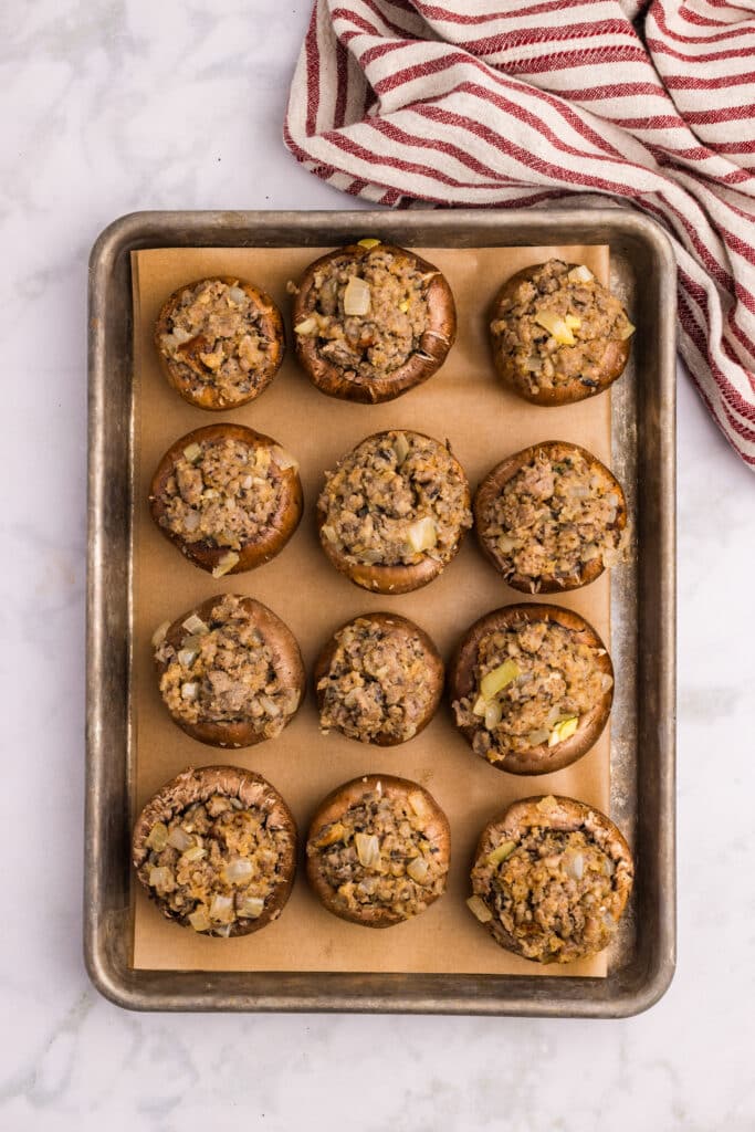 A plate of stuffed mushrooms topped with breadcrumbs and chopped herbs.