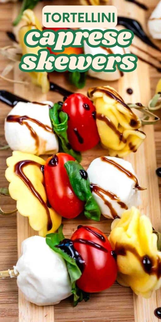 Close-up of tortellini caprese skewers on a wooden board, each skewer with mozzarella, tortellini, tomato, and basil, drizzled with balsamic glaze. Text at the top reads “Tortellini Caprese Skewers.”.